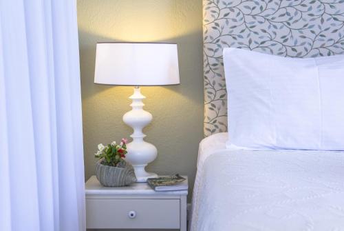 a white lamp on a night stand next to a bed at Kenta Beach Hotel in Agios Ioannis Pelio