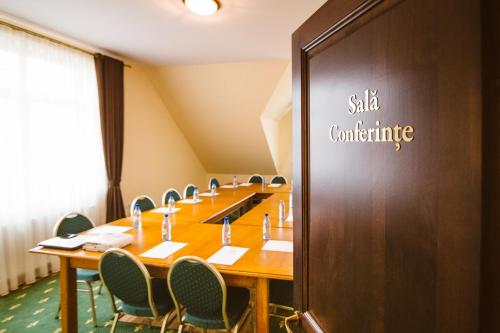 a conference room with a long table and chairs at Karlhof in Sebeş