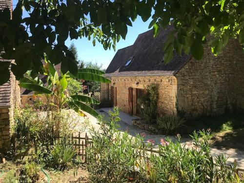 uma casa de tijolos com um jardim em frente em Grange restaurée à la campagne em Tamniès