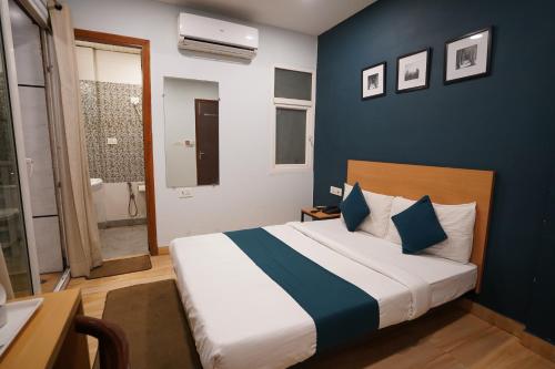 1 dormitorio con 1 cama con pared azul en Hotel Lyf Corporate Suites Meera Bagh en Nueva Delhi
