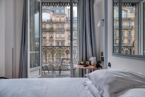 um quarto com uma cama e uma grande janela em Stella Etoile em Paris