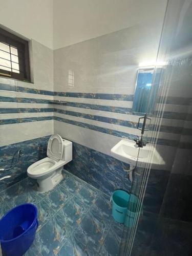 a bathroom with a toilet and a sink at Vacation Guest House in Trivandrum