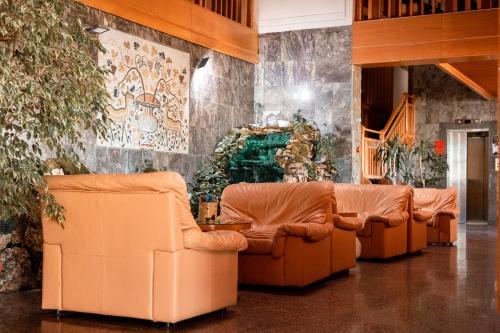 a row of orange leather couches in a lobby at Hotel Molika in Magarevo