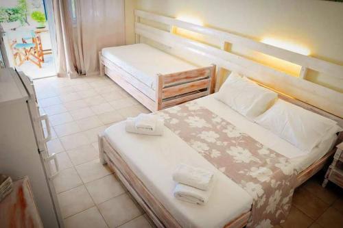 sypialnia z 2 łóżkami i ręcznikami w obiekcie Peaceful Bay w mieście Megas Gialos - Nites