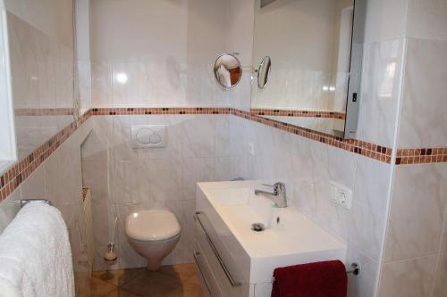 La salle de bains blanche est pourvue d'un lavabo et de toilettes. dans l'établissement Regina, à Garmisch-Partenkirchen