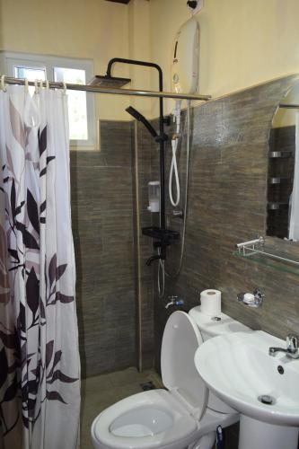 e bagno con doccia, servizi igienici e lavandino. di Angel Nido Resort a El Nido
