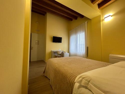 sypialnia z łóżkiem, oknem i telewizorem w obiekcie Laguna Blu Mestre Venezia w Mestre