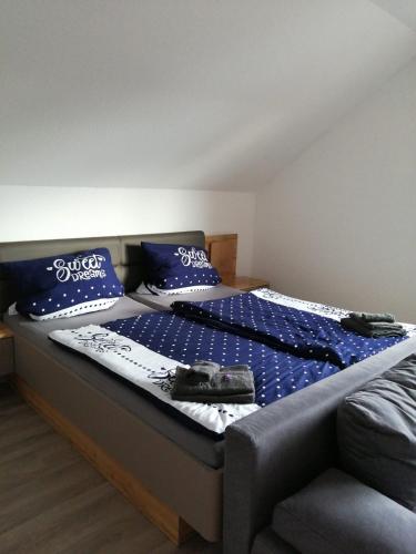 a bedroom with a bed with blue sheets and blue pillows at Dorfidyll im Grünen in Mittelherwigsdorf