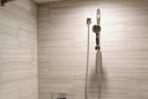 y baño con ducha con cabezal de ducha. en Detroit Marriott Southfield, en Southfield