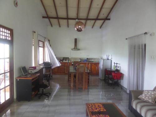 a living room with a table and a kitchen at Mount View Holiday Home in Matale