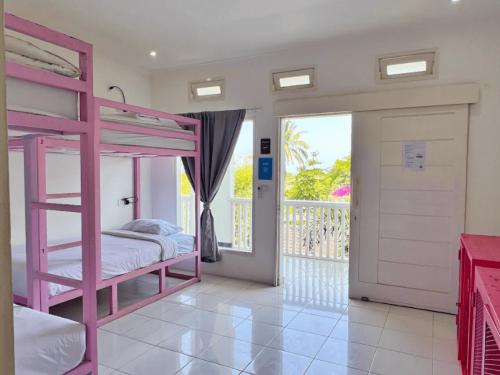 a pink bunk bed in a room with a balcony at Mad Monkey Kuta Lombok in Kuta Lombok