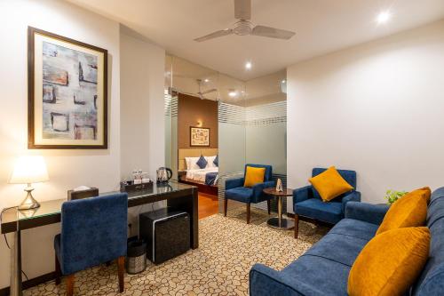 a living room with a blue couch and a desk at Hotel 91 Golf Course Road in Gurgaon