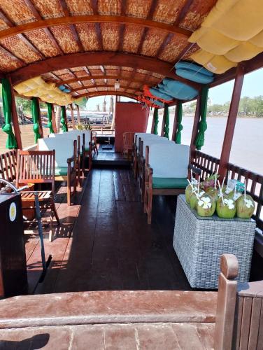 a boat with tables and chairs on the water at Khách Sạn Vinhomes Huỳnh Hotel in Ben Tre