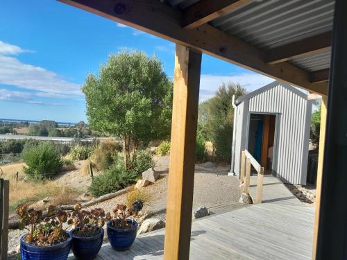 une terrasse couverte en bois avec plusieurs plantes en pot dans l'établissement Richmond Cabins, à Hope