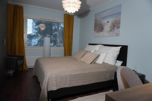 a bedroom with a bed and a window and a chandelier at Easypass Apartmenthotel in Helsinki