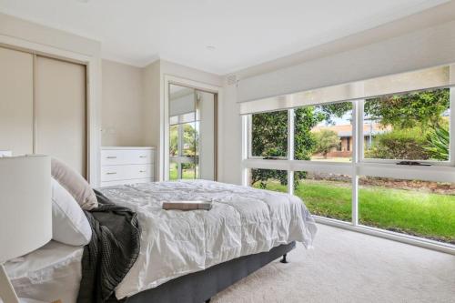a white bedroom with a bed and large windows at NEW! Modern, Relaxing 2BR Retreat in Mentone, Victoria in Mentone