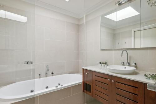 a white bathroom with a tub and a sink at NEW! Modern, Relaxing 2BR Retreat in Mentone, Victoria in Mentone