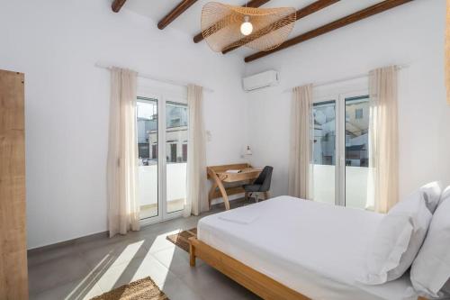 a bedroom with a bed and a table and windows at Μπαλκόνι με θέα / Viewtiful balcony in Adamas