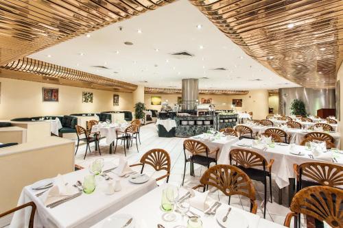 a dining room with white tables and chairs at Holiday Inn Lisbon-Continental by IHG in Lisbon