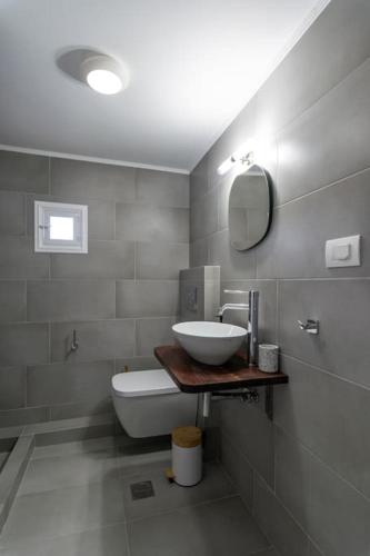 a bathroom with a sink and a toilet and a mirror at Μπαλκόνι με θέα / Viewtiful balcony in Adamas