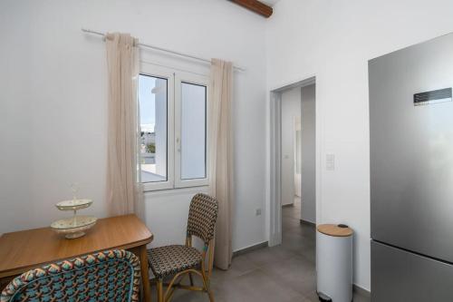a dining room with a table and chairs and a window at Μπαλκόνι με θέα / Viewtiful balcony in Adamas