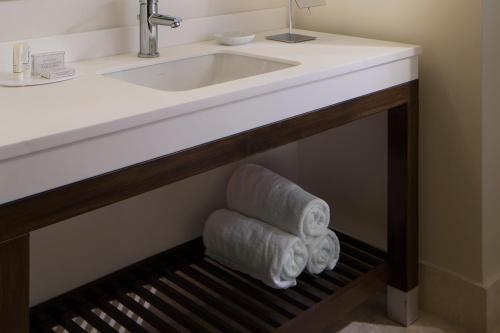 - Baño con lavabo y dispensador de toallas en Courtyard Miami Dadeland, en Miami