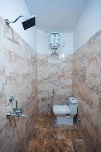 a bathroom with a toilet and a water tank at HOTEL JSR KEDAR in Varanasi