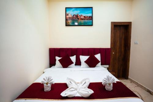 a bedroom with a bed with white bows on it at HOTEL JSR KEDAR in Varanasi