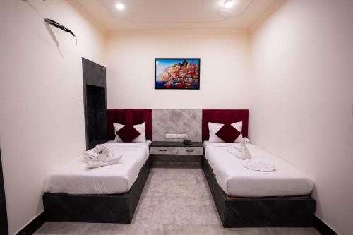 a room with two beds and a painting on the wall at HOTEL JSR KEDAR in Varanasi