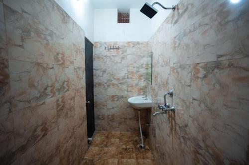 a bathroom with a sink and a shower at HOTEL JSR KEDAR in Varanasi