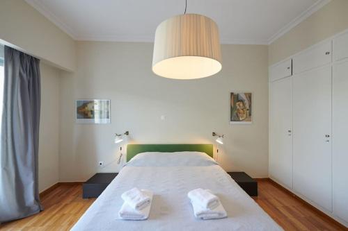 1 dormitorio con 1 cama grande y 2 toallas. en Apartment in the heart of the city en Atenas