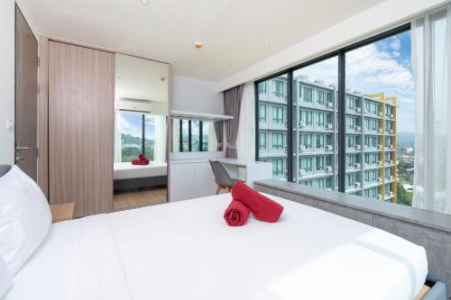 1 dormitorio con 1 cama blanca grande y ventanas grandes en Central Hill View Condo A716D*2BR Apartment*Ideal Location: Shopping, Relax, Adventure, en Ban Ket Ho