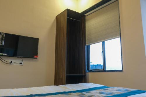 VR Comforts في مومباي: غرفة نوم مع سرير ونافذة مع تلفزيون بشاشة مسطحة