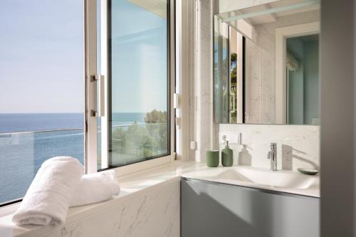 a white bathroom with a window and a sink at VILLA ILLA BLANCA in Tamariu