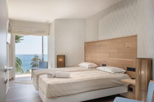 ein Schlafzimmer mit zwei Betten und einem großen Fenster in der Unterkunft VILLA ILLA BLANCA in Tamariu