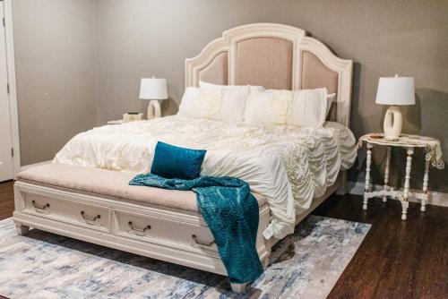 a bedroom with a large white bed with blue pillows at Country Cottage - Broussard in Broussard
