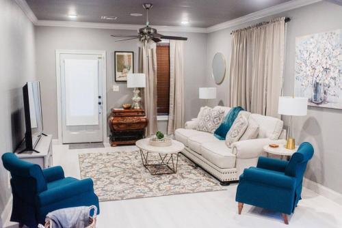 a living room with a couch and two blue chairs at Country Cottage - Broussard in Broussard