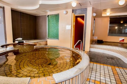 a bathroom with a large circular tub in a room at Miyazaki Daiichi Hotel in Miyazaki