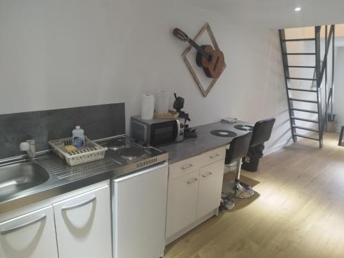 une cuisine avec un comptoir avec un évier et un micro-ondes dans l'établissement studio musique, à Arras
