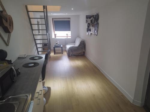 un salon avec un escalier et une chaise dans l'établissement studio musique, à Arras