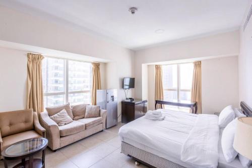 a bedroom with a bed and a couch and a table at Ensuite Rooms in CoLiving Apartments in Marina in Dubai