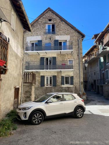 BeauvezerにあるMaison de village de 1802, fraîchement rénovée à Beauvezer 04370の建物前に駐車した白車