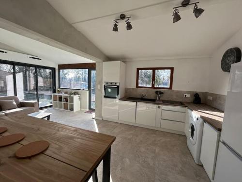 une grande cuisine avec des armoires blanches et une table dans l'établissement 