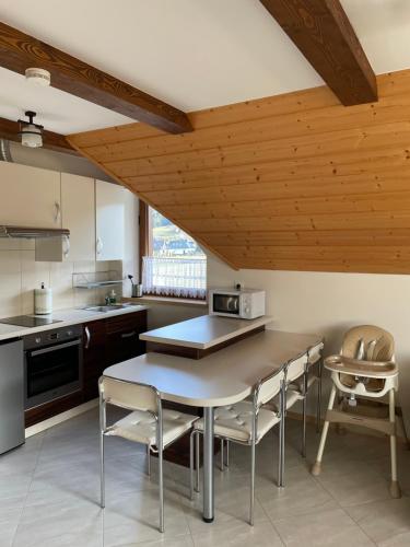 a kitchen with a table and chairs in a room at PrzyStań w Gorcach in Konina