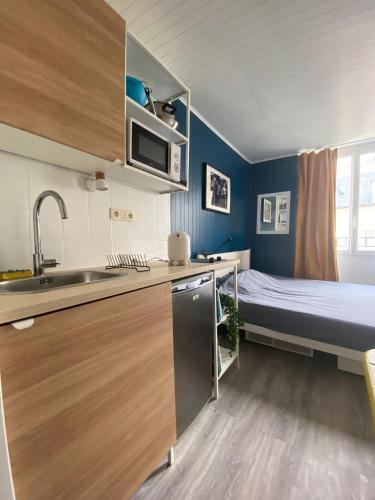 - une petite cuisine avec un lit dans une chambre dans l'établissement Bright Central Flat PARIS, à Paris