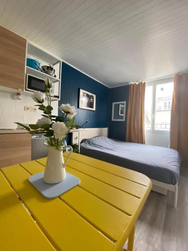 une chambre avec un lit et une table avec un vase de fleurs dans l'établissement Bright Central Flat PARIS, à Paris
