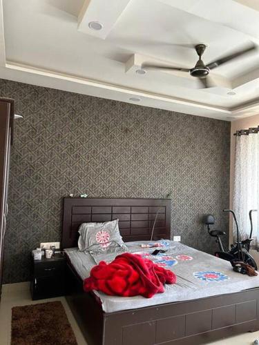 a bedroom with a bed with a red blanket on it at Sukh sagar Lifestyle in Jabalpur