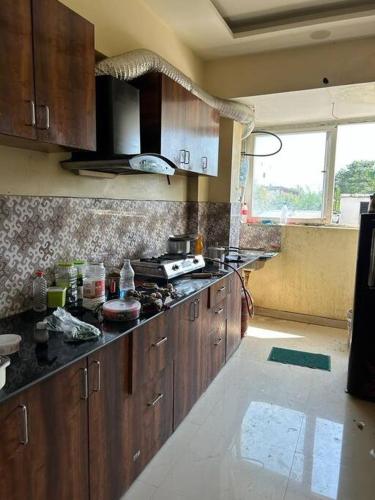 a kitchen with wooden cabinets and a stove top oven at Sukh sagar Lifestyle in Jabalpur