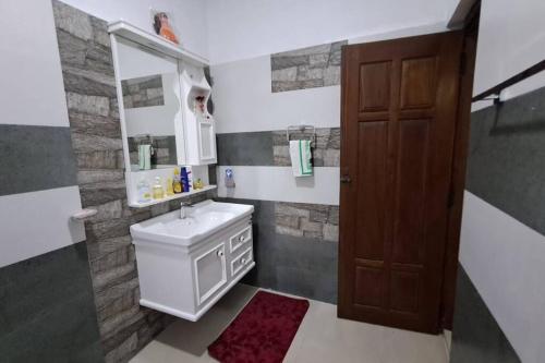 a bathroom with a sink and a mirror at Spacious Greenery Homely Home in Ja-Ela