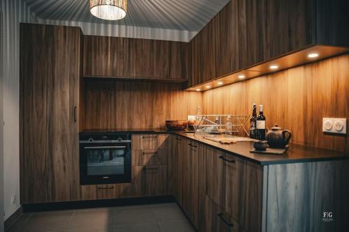 une cuisine avec des armoires en bois et un four à plaques de cuisson dans l'établissement Le Méribel - Conciergerie de la Yaute, à Sallanches